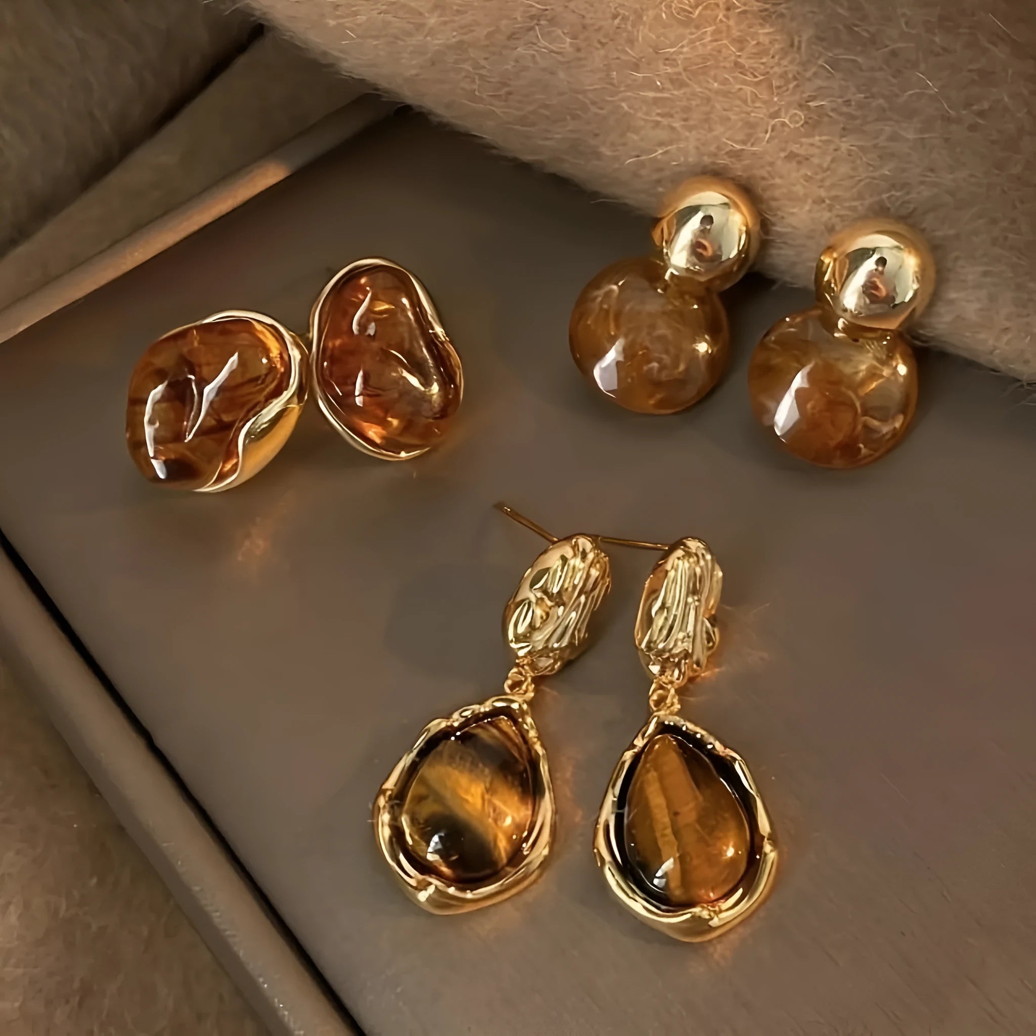 Three pairs of geometric tassel earrings with electroplated finishes in different styles