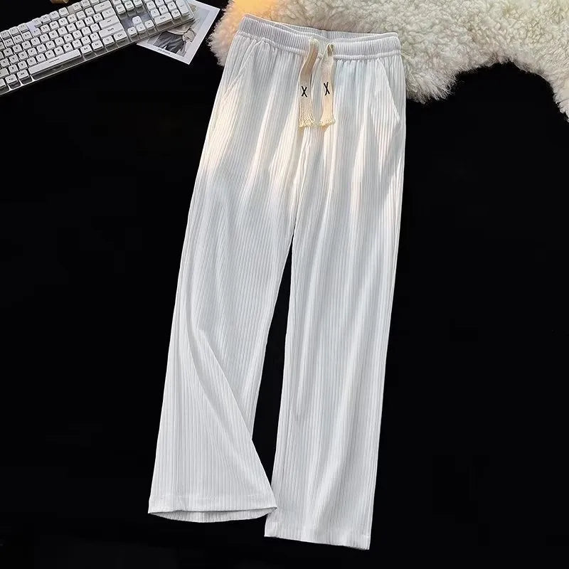 Men's loose straight-leg casual cotton trousers in black, shown flat.