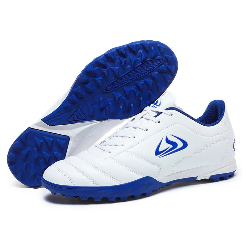 Low-top outdoor soccer shoes in a black and blue broken nails colourway on a turf background.