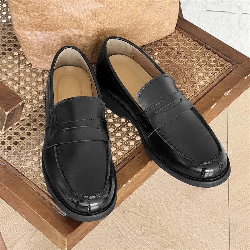 Black men's classic slip-on derby leather shoes with a rubber sole, shown in a mature style.