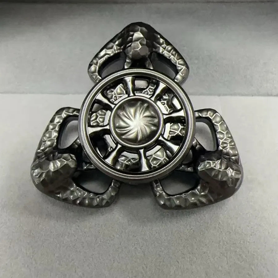 A metal butterfly-shaped fingertip gyro fidget toy spinning on a surface.