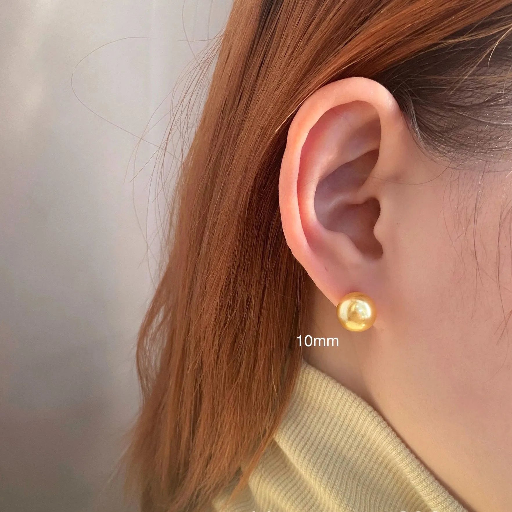 A pair of large pearl stud earrings with a geometric silver setting and an eight-point star detail.
