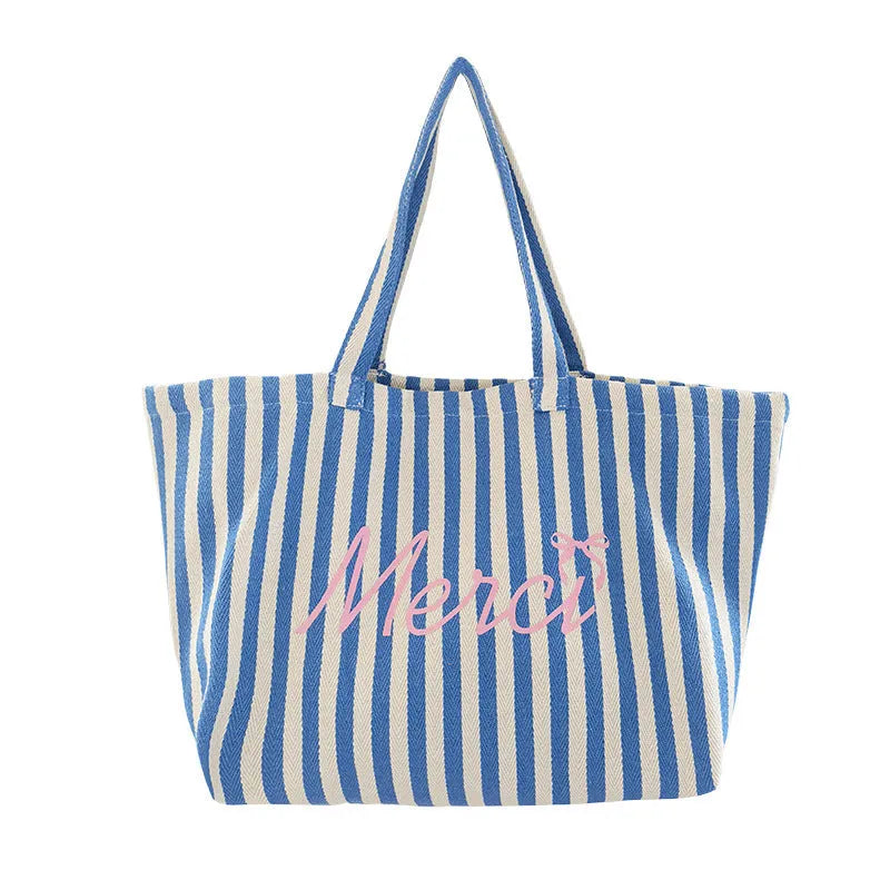 Blue, pink, and white striped canvas bag with printed letters on the front.