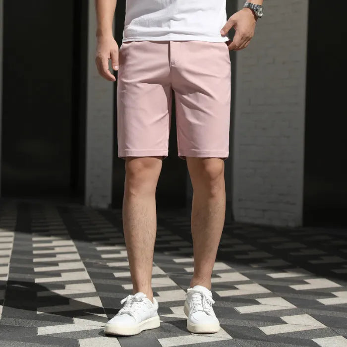 Man wearing loose-fit beige mid-length casual trousers with an elasticated waistband.
