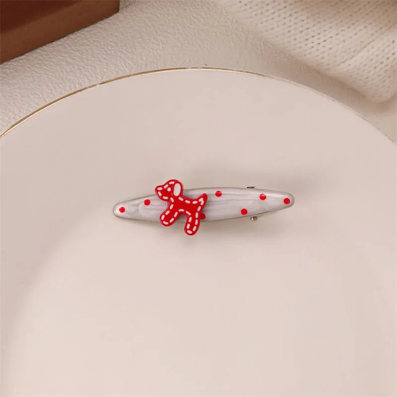 Red love heart-shaped plastic hair clip with retro dots and a willow leaf silhouette on a white background.