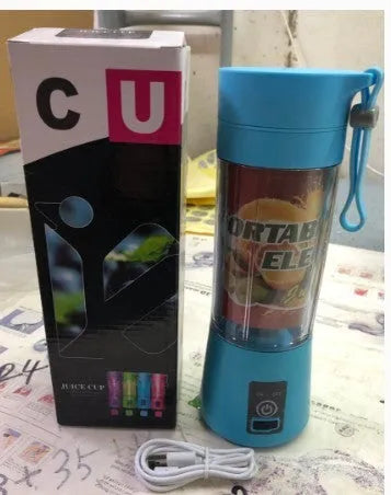 Pink mini USB electric fruit juicer with carrying rope on a kitchen countertop.