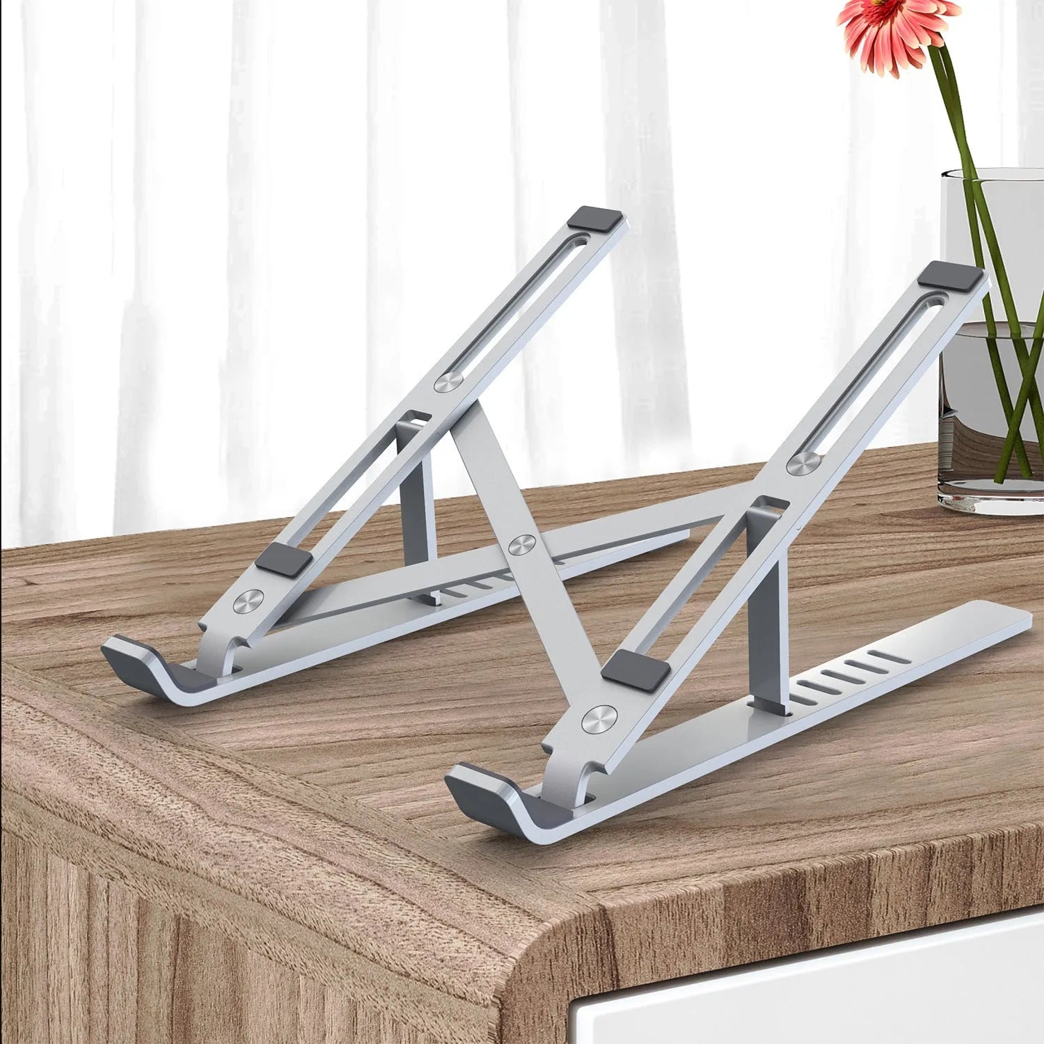 Silver aluminium alloy laptop stand in folded position showing adjustment gears
