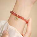 A New Chinese style glass bracelet with strawberry quartz stones and a blessing card.