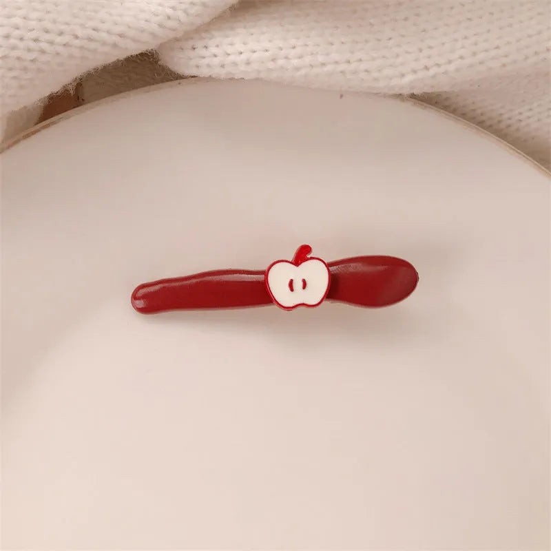 Red love heart-shaped plastic hair clip with retro dots and a willow leaf silhouette on a white background.