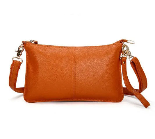 Lady's cowhide leather slant bag in apricot colour with hand strap and shoulder strap showing zipper compartments