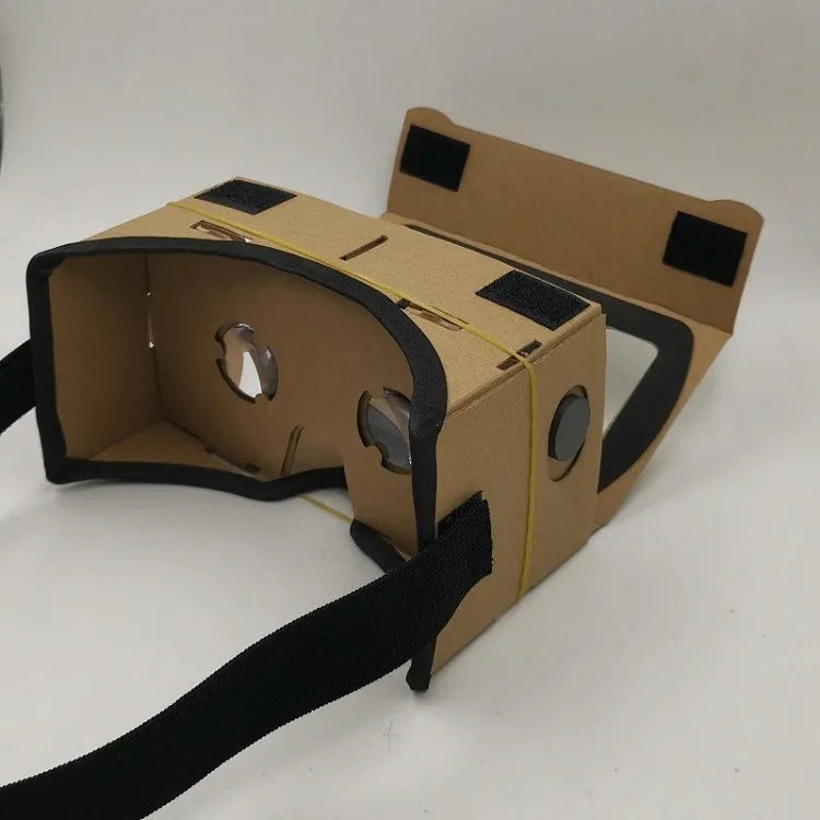 Pink and white foldable VR cardboard glasses for mobile phones, showing 3D lenses and rubber band.