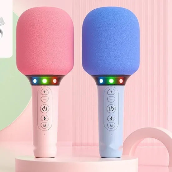 Pink Bluetooth children's handheld karaoke microphone with built-in speaker on white background