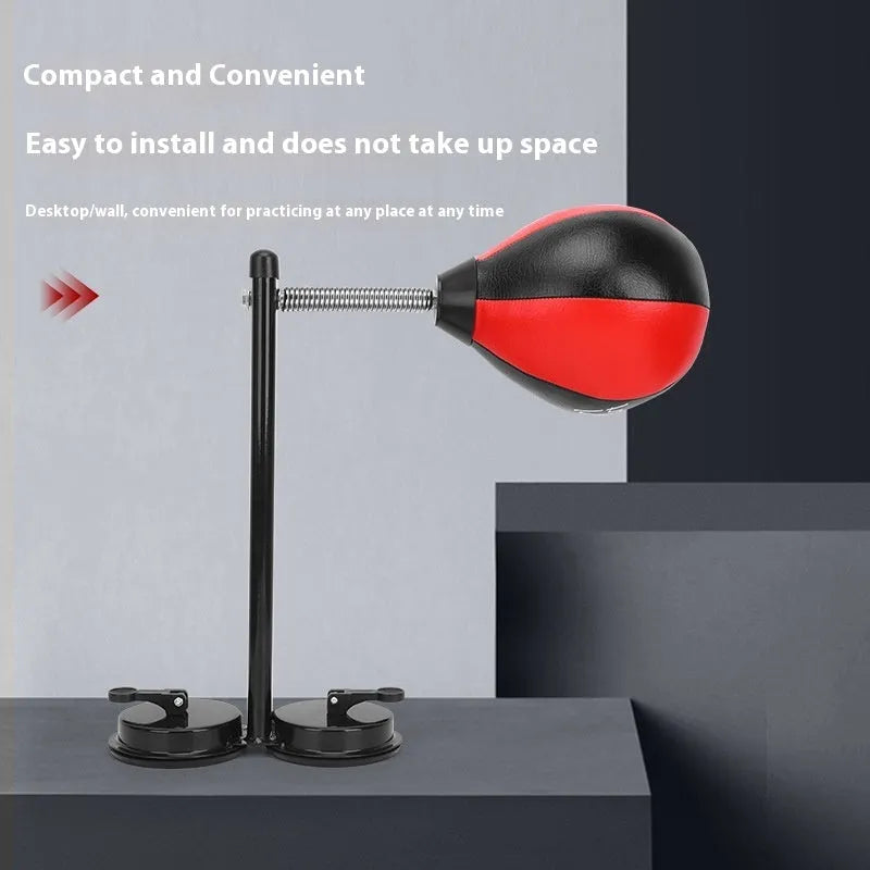 Pear-shaped hanging boxing training ball with red and black head on elastic cord and dual suction cup base.