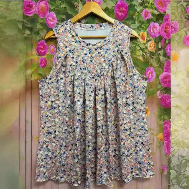 A black floral print sleeveless vest on a hanger, showing its loose fit and round neck design.