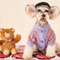 Female dog wearing a colourized wool pet cardigan in pink with a vest-style fit, side view