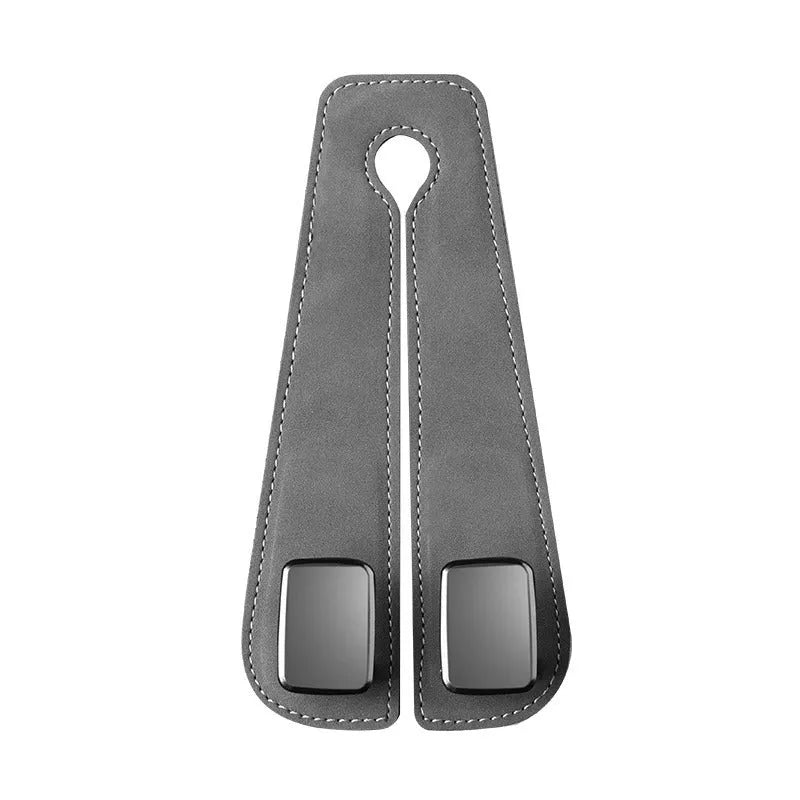 Black suede and metal car seat hook organiser hanging on a car headrest.