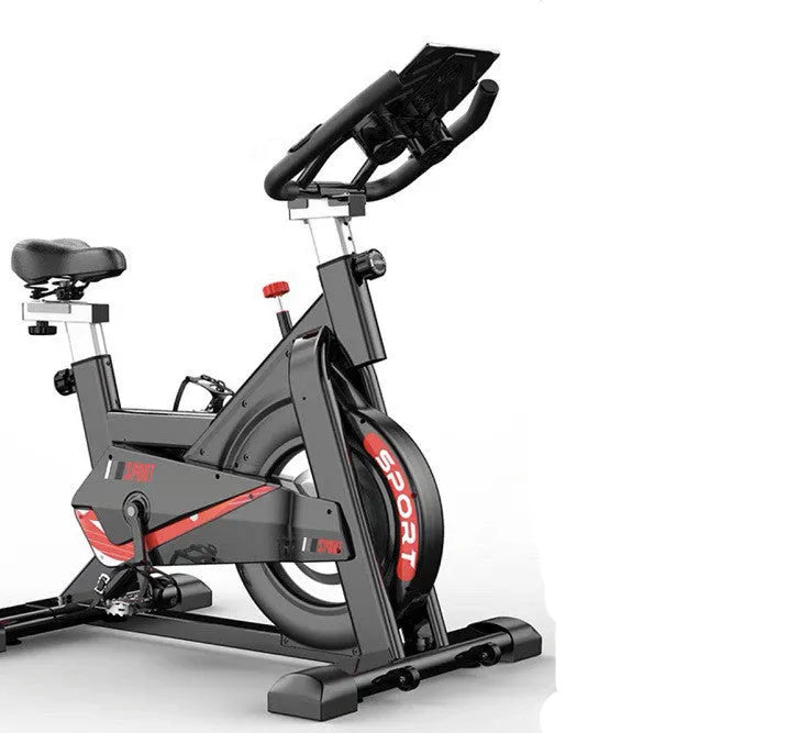 Black upright spinning bike with console and infinite resistance knob on a home gym floor