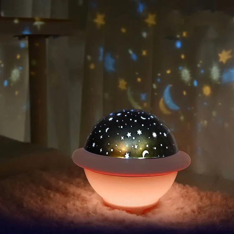 Green UFO-shaped star projection night light on wooden table showing star patterns on wall