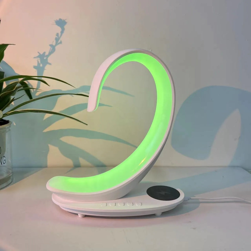 Multi-functional white swan desktop light with wireless charger, Bluetooth speaker, and colourful atmosphere light on a desk