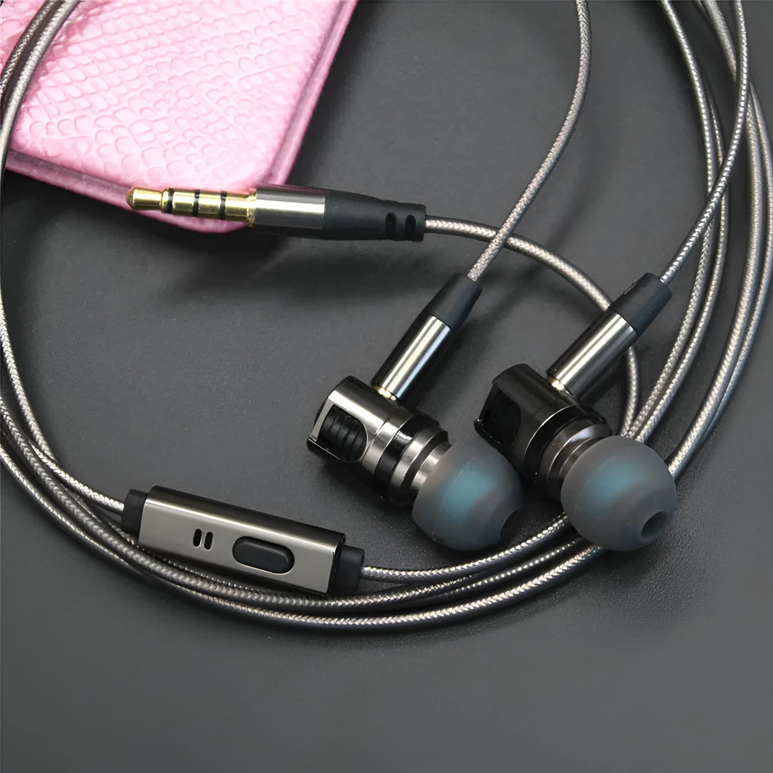 Titanium grey metal in-ear earphones with a detachable cable on a grey background.