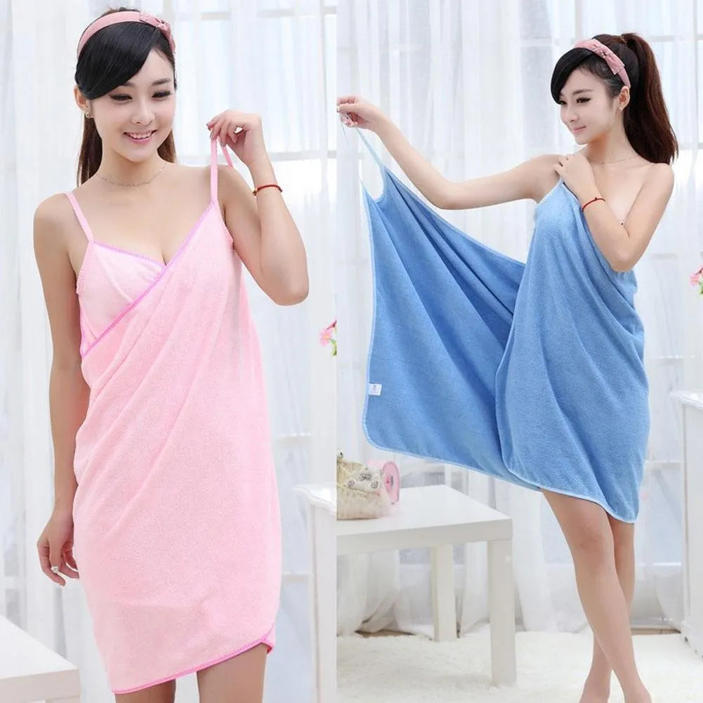 A person wearing a long pink polyester beach towel as a dress wrap at the seaside.