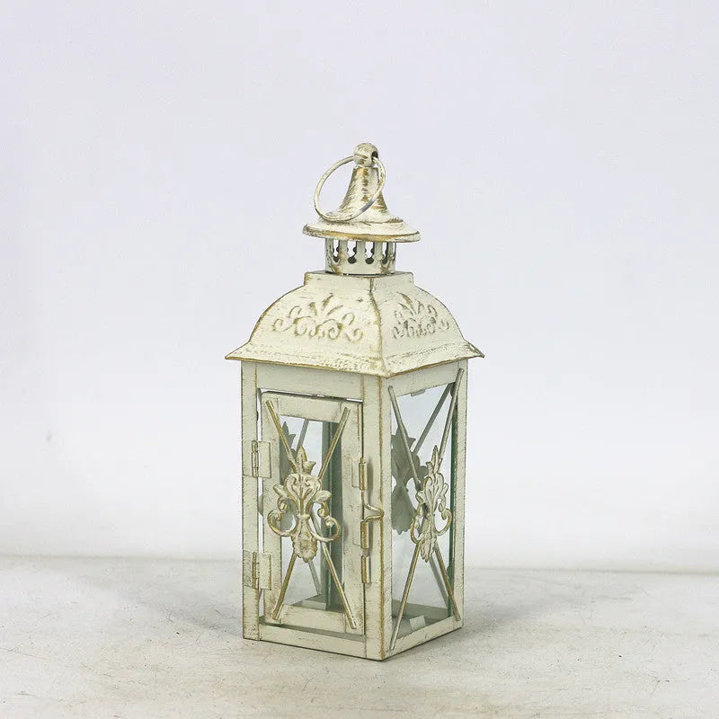 European wrought iron storm lantern with tempered glass in black or white gold finish, shown in small, medium, and large sizes.