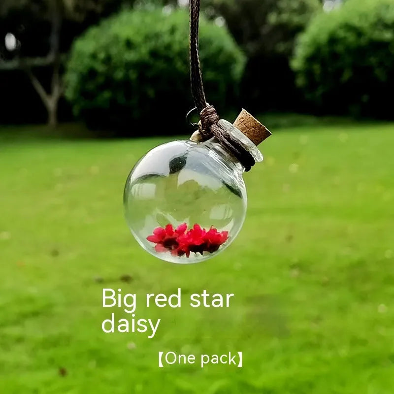Glass car perfume pendant with preserved flower decoration hanging in car interior