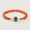 Women's bracelet made of round red South agate beads from Sichuan on a black elastic cord.