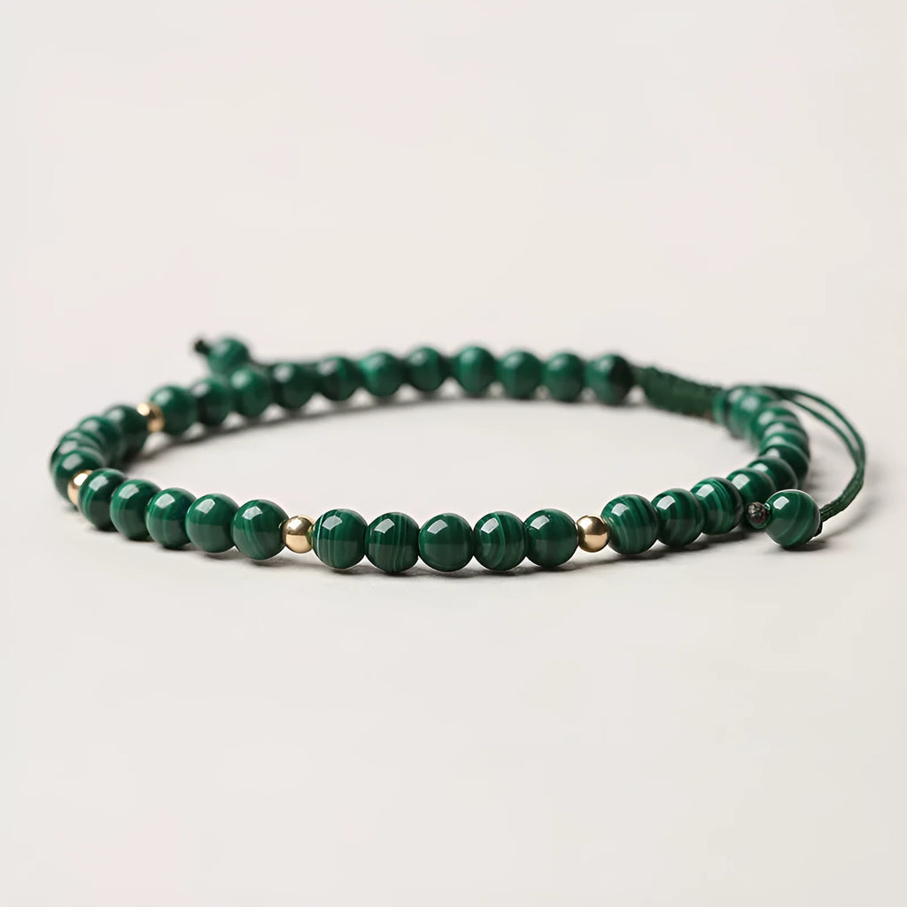 Green malachite stone bracelet with golden beads on woven strap, zodiac animal motif.