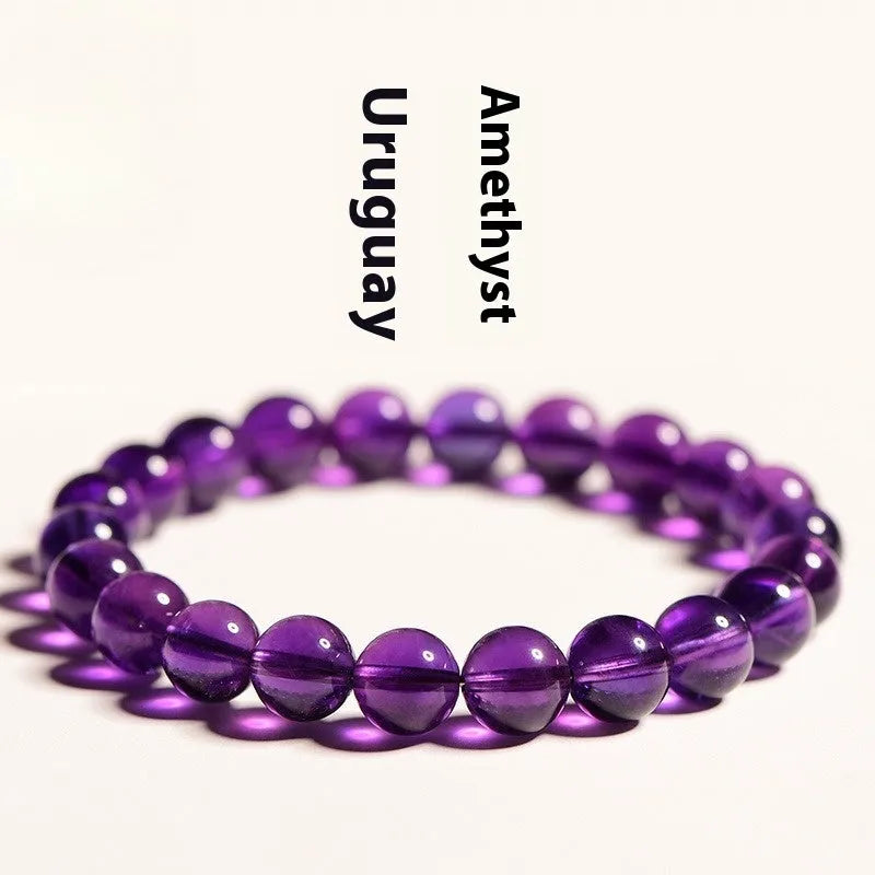 Natural amethyst Uruguay bracelet with scattered polished beads on a white background.