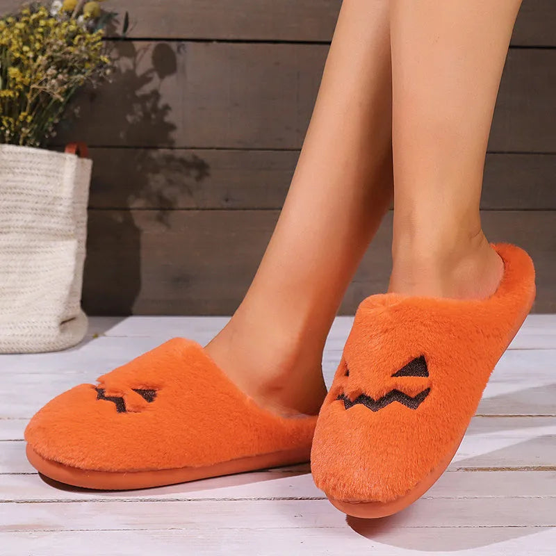 Orange pumpkin-shaped coral velvet plush slippers with a flat PVC sole.