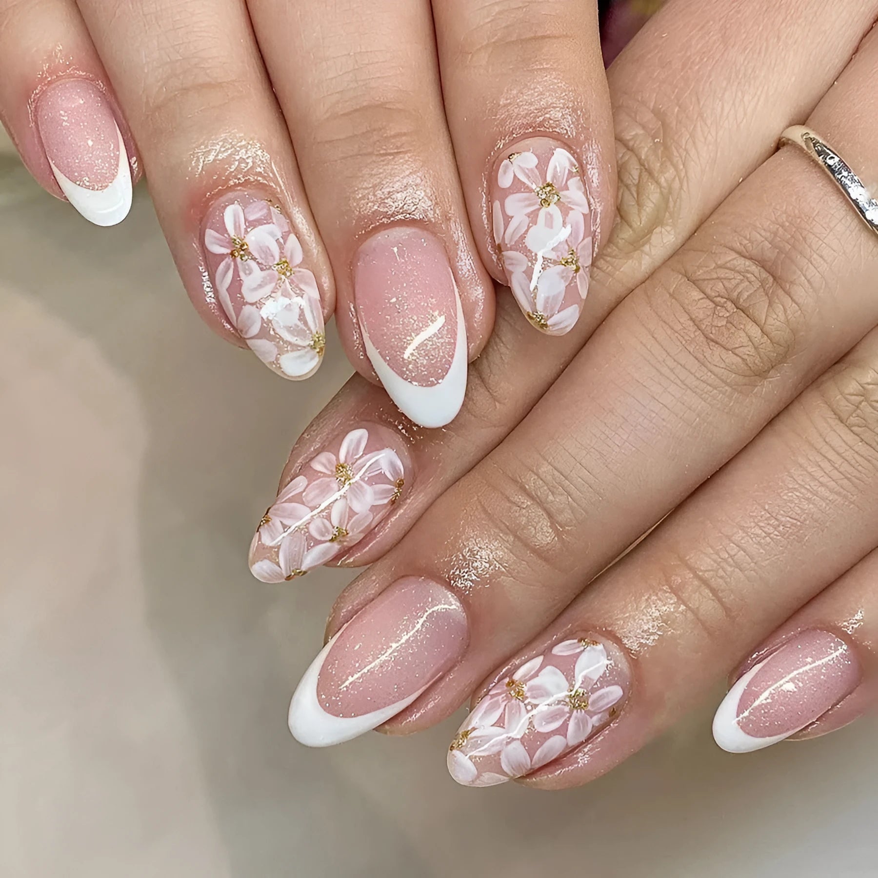 Short almond shaped artificial fingernails with French tips and glitter powder flower decorations, colour C625.