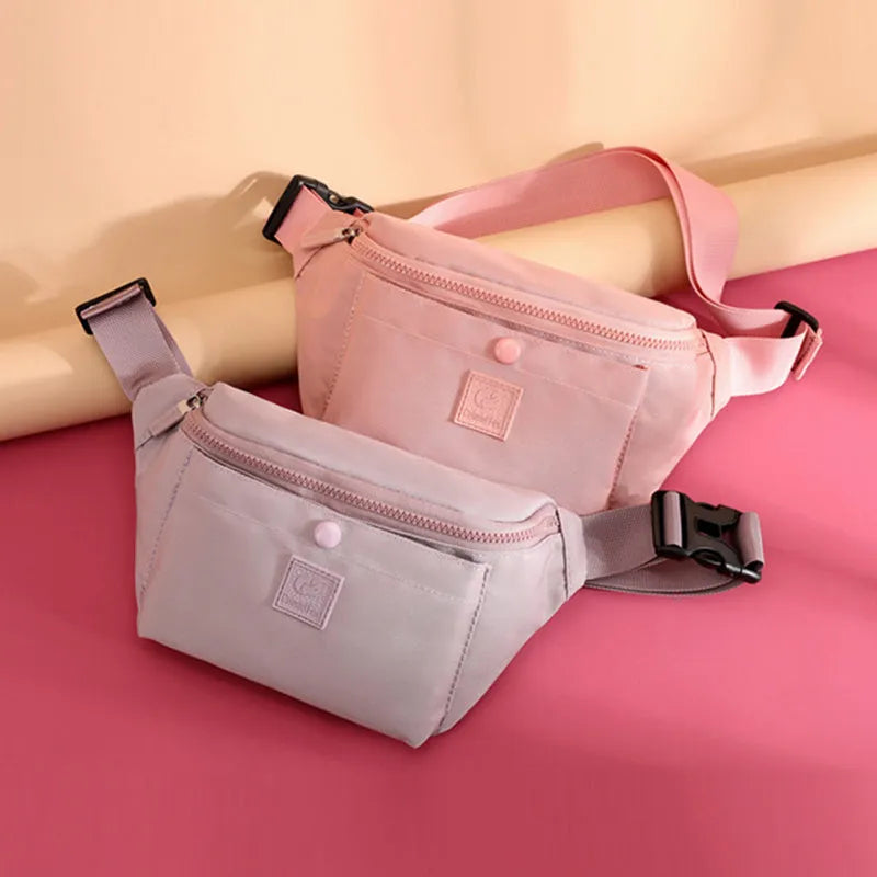 Women's nylon crossbody fanny pack in black with zippered compartments and letter detail.