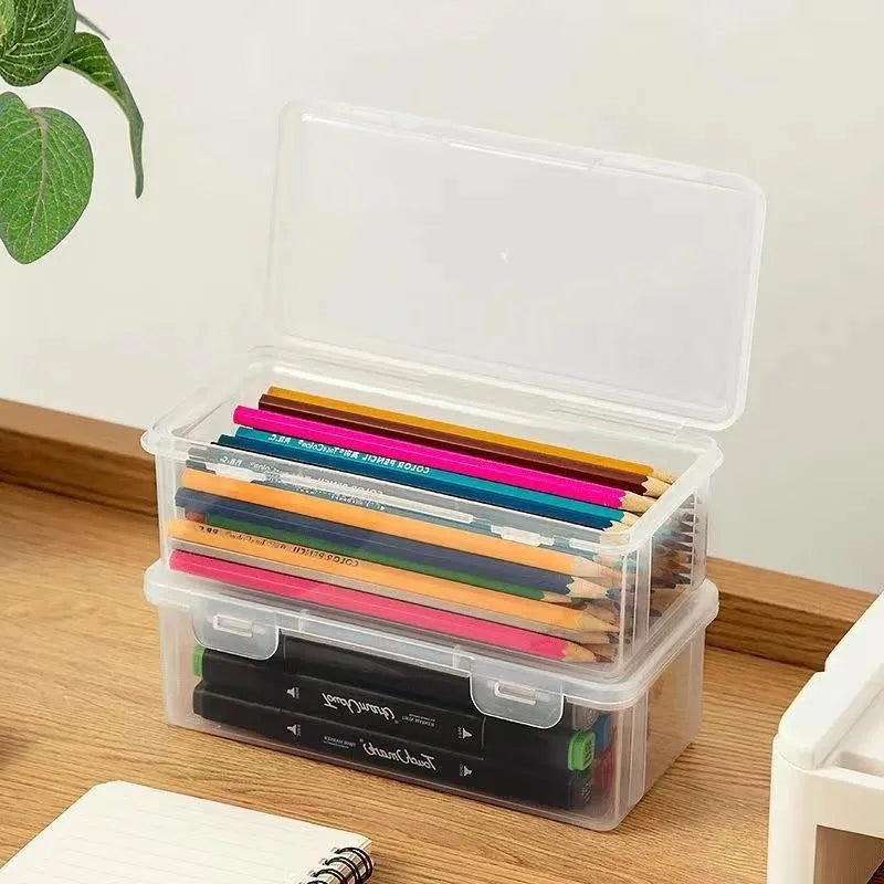 Large clear plastic stationery storage box filled with coloured pencils and crayons