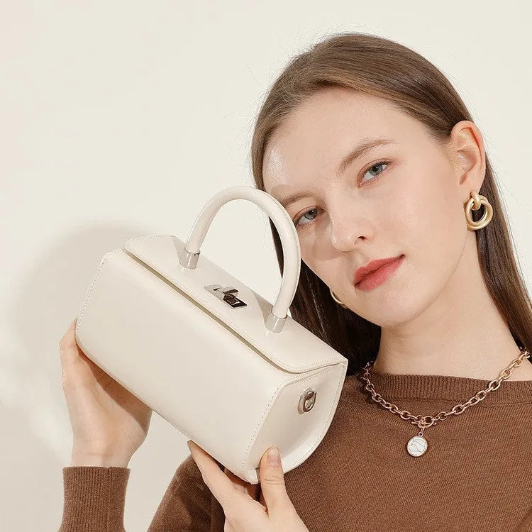 Women's leather crossbody bag in clamshell design showing internal phone and file pockets.