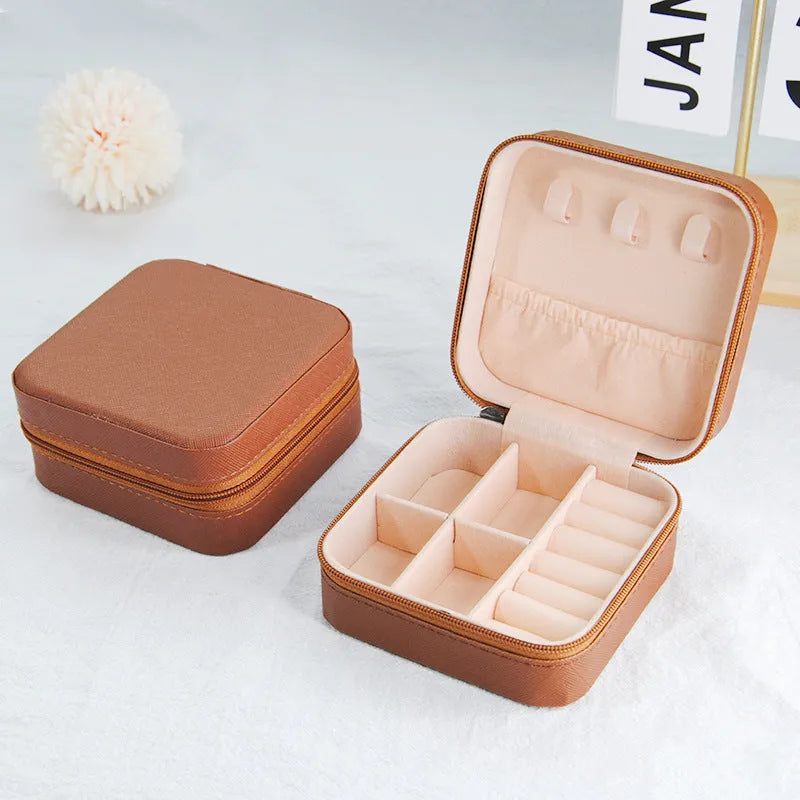 Small leather jewellery box in cross pattern, 10cm size, for earrings and rings, on a flat surface.