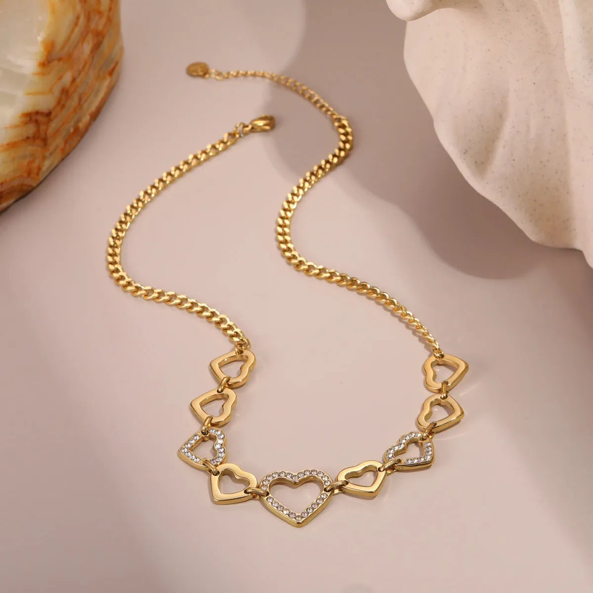 Geometric heart-shaped stainless steel pendant necklace with 18K gold finish on clavicle-length regular chain
