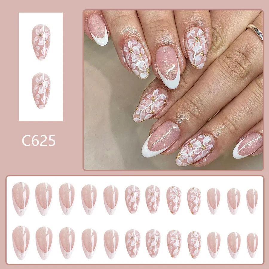 Short almond shaped artificial fingernails with French tips and glitter powder flower decorations, colour C625.