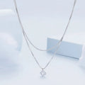Close-up of a double-layer sterling silver necklace with a pearl-style chain, showing its layered design and silver finish.