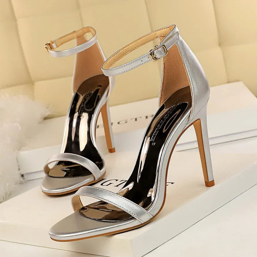 Open toe high heels with an ankle strap and buckle in a choice of six solid colours.