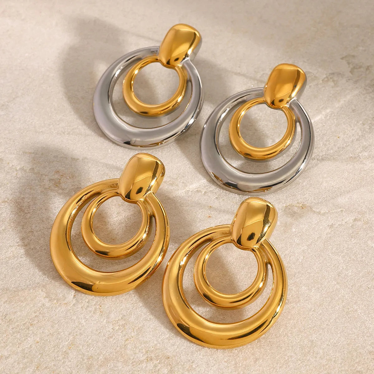 Round golden double layer hollow stud earrings for women with a geometric design.