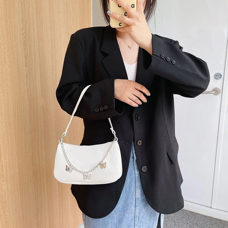 Women's black retro-style crossbody bag with chain strap and structured square shape.