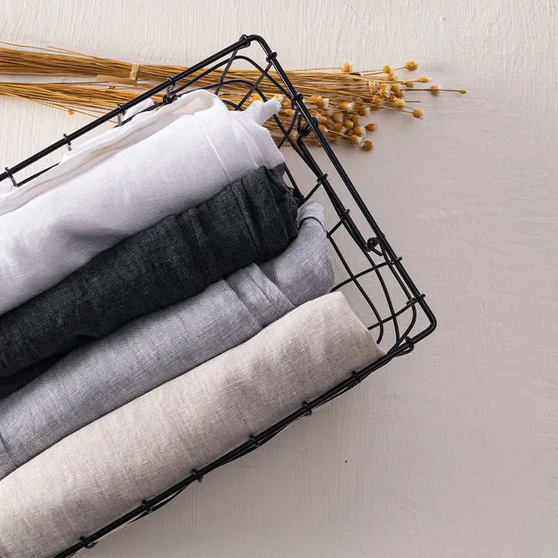 Men's straight-leg linen trousers in light gray shown laid flat.