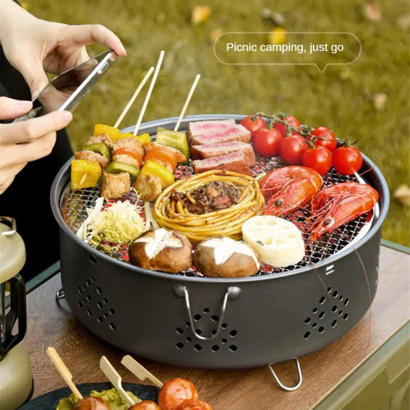 Portable stainless steel campfire grill with detachable parts and storage bag on grass