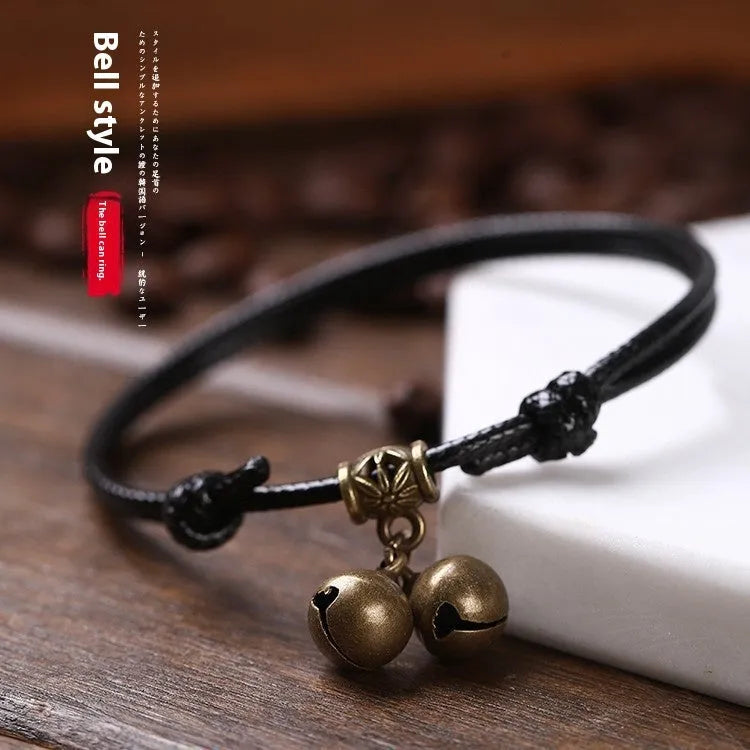Adjustable black nylon dog collar with a brass bell for a small pet.