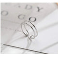 Silver plated geometric cross ring with adjustable opening on a plain background