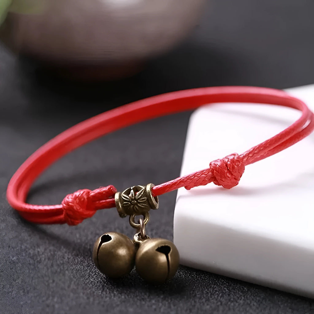 Adjustable black nylon dog collar with a brass bell for a small pet.