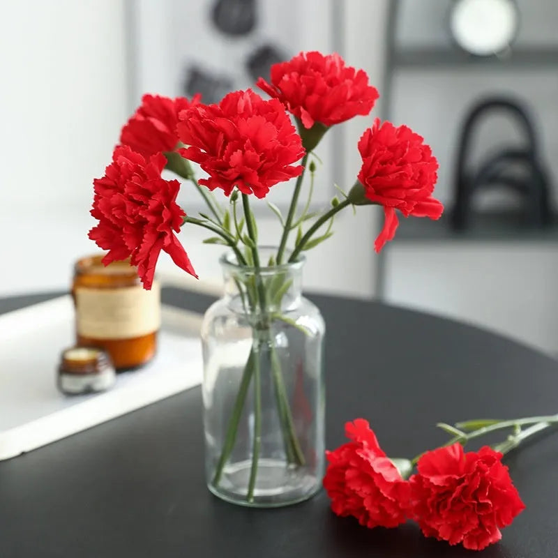 Single artificial mini carnation fake flower in soft rubber and silk material on white background
