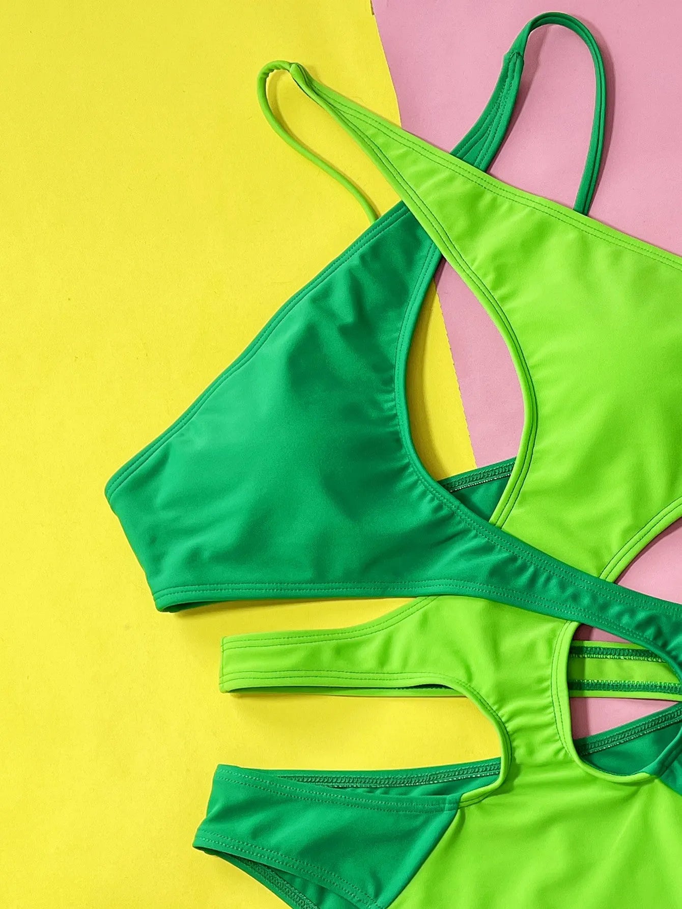 Green women's one-piece swimsuit with hollow contrast colour design on mannequin