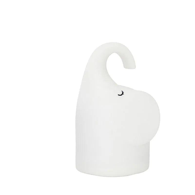 DOMI Elephant style silicone and plastic LED night light with warm white glow on a bedside table.